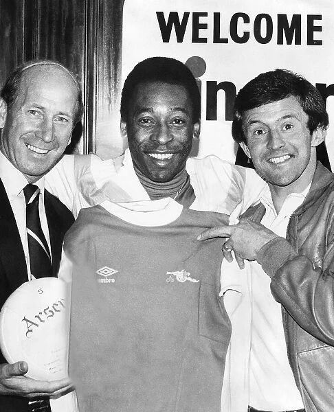 Brazilian footballer Pele with John Hollins and Bobby Charlton size up an Arsenal shirt