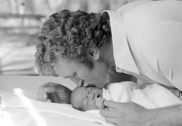 Former British European Heavyweight champion boxer Joe Bugner kisses his new born baby