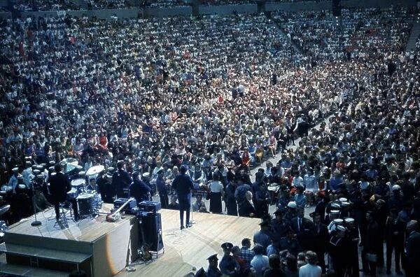 British pop group The Beatles playing to a huge crowd out a packed out music venue during