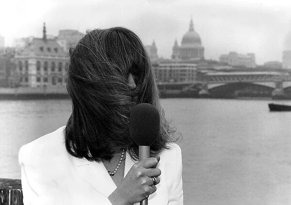 Caron Keating TV Presenter holding microphone hair blowing over her face