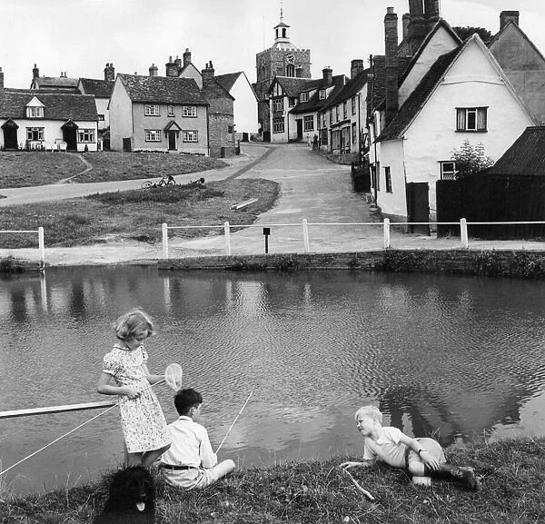 Children fishing for tadpoles and minnows in the village pond at Finchingfield Essex