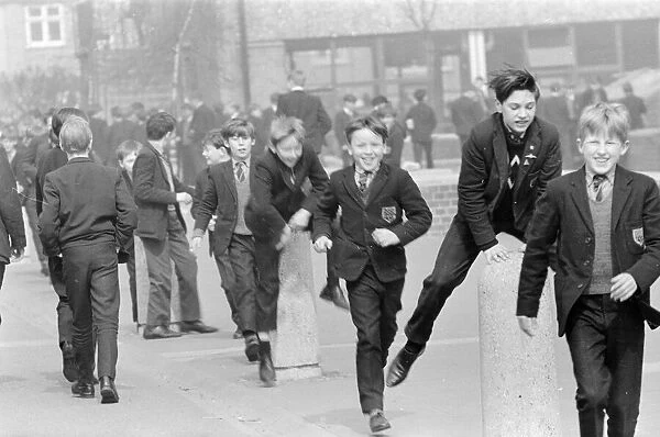 Children of a London Comprehensive school leap frogging over one of the concrete pillars