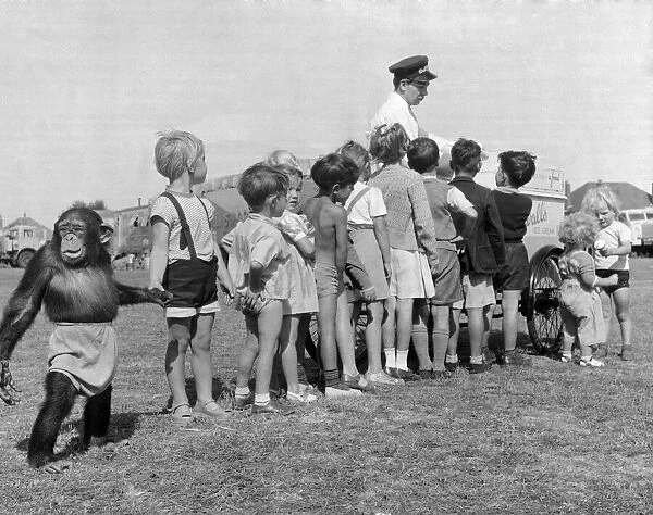 Children queue with their Chimpanzee friend for an ice cream at Billy Smart Circus