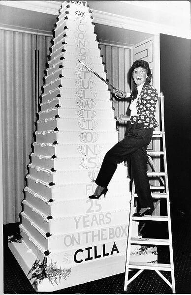 Cilla Black TV Personality climbs a ladder with a sward to cut the huge party cake in