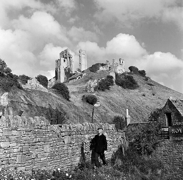 Corfe Castle, The Square, Wareham, Dorset, rises behind a drystone wall