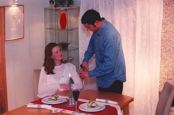 A couple enjoy a romantic candlelit dinner at home