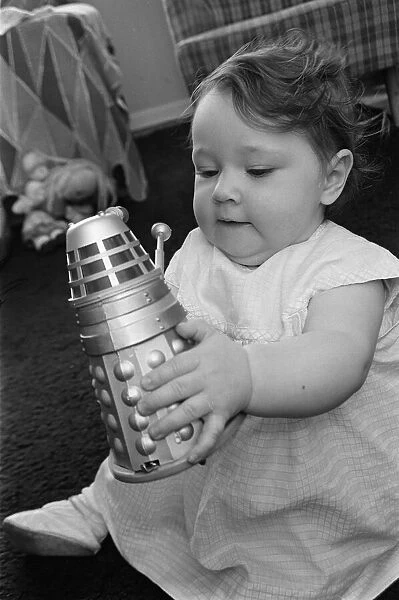 The daughter of Raymond Cusick designer of the Daleks from Doctor Who playing with a toy