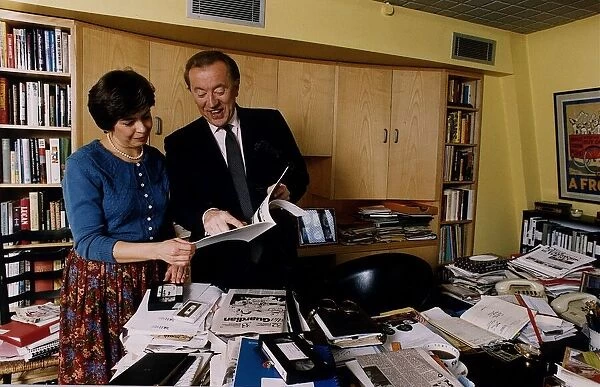 David Frost TV Presenter checking through paperwork with an assistant