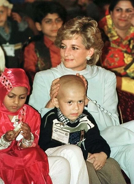 Diana, Princess of Wales, touches the head of Mohammed Ashrif who has lost his hair after