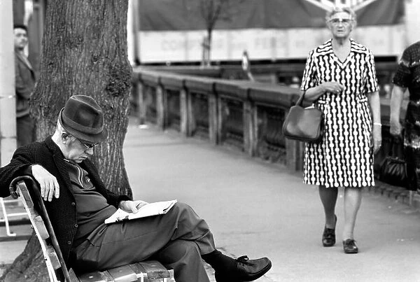 An elderly gent reading his newspaper on a park bench in Luxembourg City