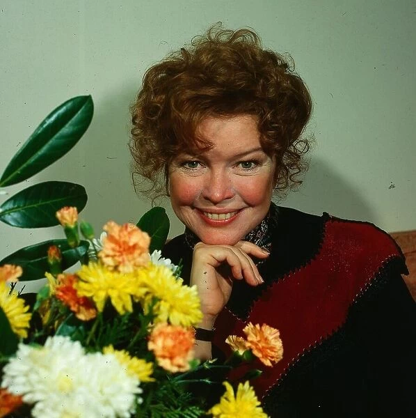 Ellen Burstyn actress March 1981 standing beside flowers hand at chin