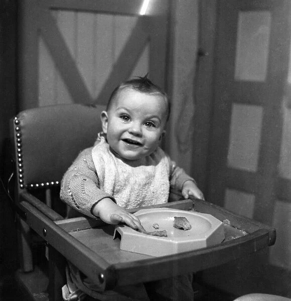 Expressions. An 11 month old child smiling with his food. January 1950