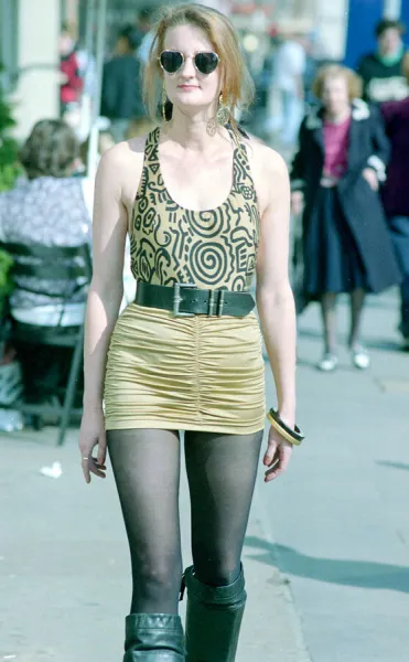 Fashion 1990s Woman walking down the street wearing a mini skirt with a leotard