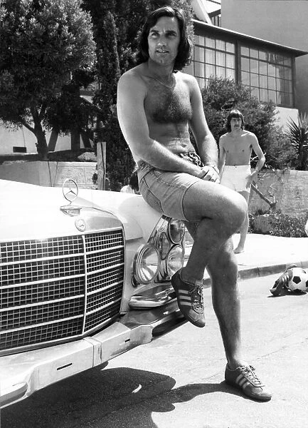 Footballer George Best poses beside his Mercedes Car June 1976