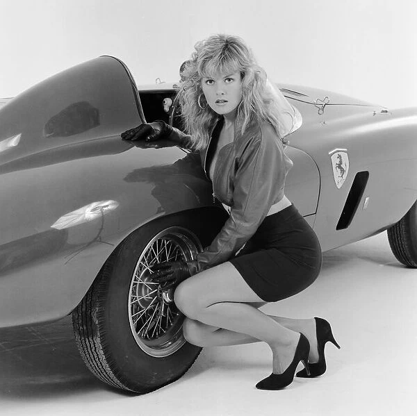 Glamour model Caroline Delahunty poses next to a Ferrari. 19th April 1988