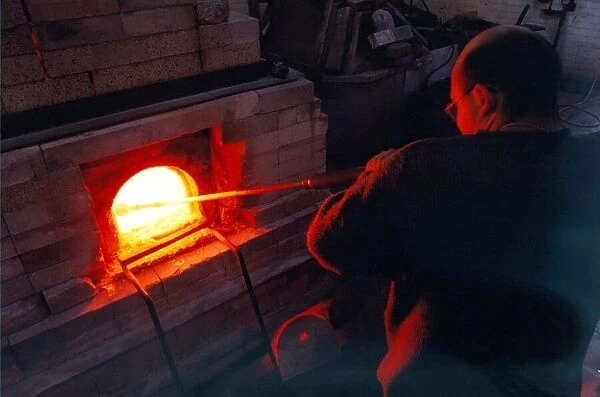 Glass blower Andy Murphy works on one of the furnaces in November 1997
