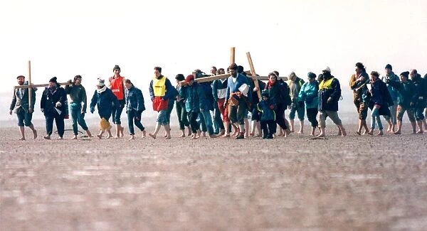 A group of pilgrims crossing the causeway at Holy Island on their way to St