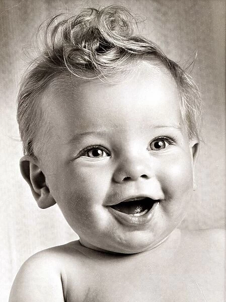 Happy baby boy with a stylish haircut. Circa 1950