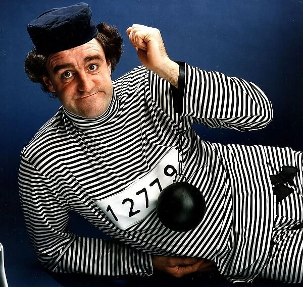 Iain McColl actor dressed as convict in striped suit ball and chain on wrist
