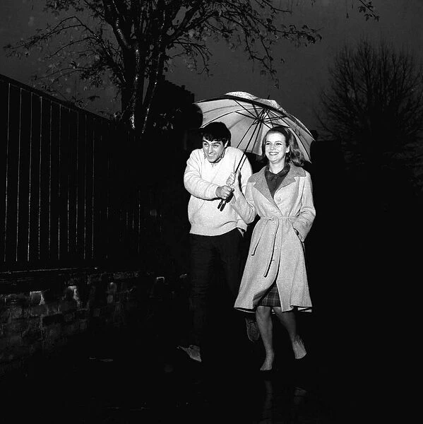 Ian McShane actor with actress Susan Farmer November 1963 walking along in the rain