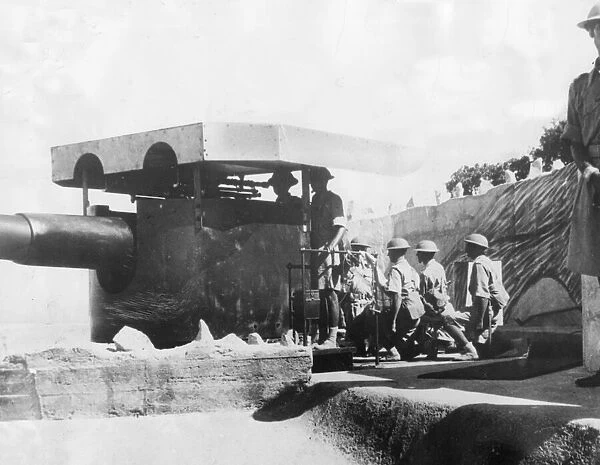 An Indian gun crew working one of Hong Kongs coast defence guns as they prepare for