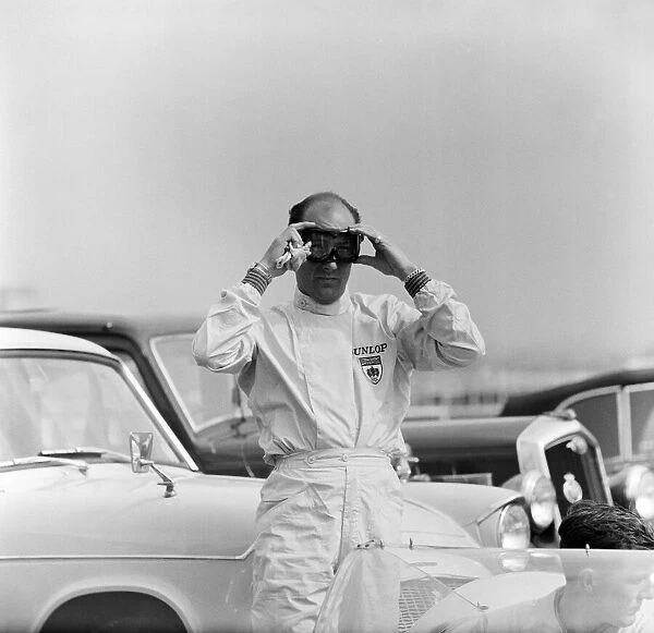 International 200 at Aintree motor circuit. Stirling Moss adjusts his goggles