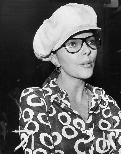 Joan Collins at London Airport wearing glasses and cap - August 1970