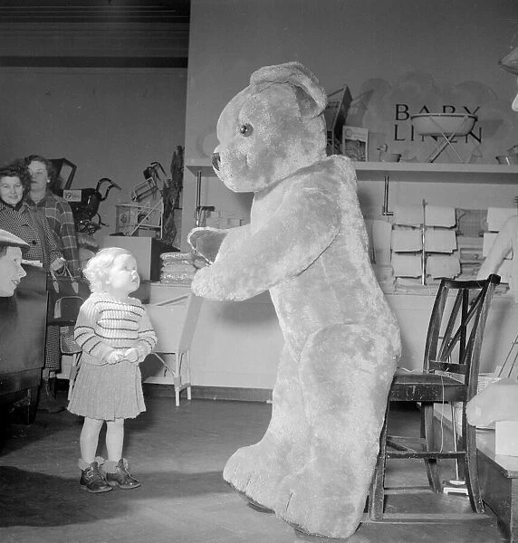 Joan Padley seems amazed by the huge teddy bear in the toy department section of Lewis