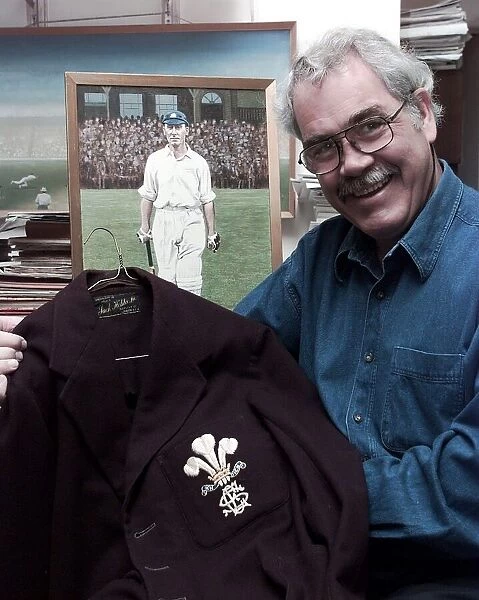 John McKenzie who run a shop of Cricket Memorabilia holds a jacket which was worn by Jack