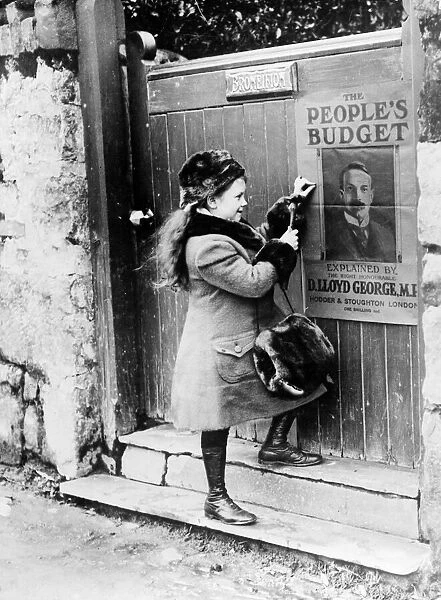 Lady Megan Lloyd George aged 8, fastens a Peoples Budget poster