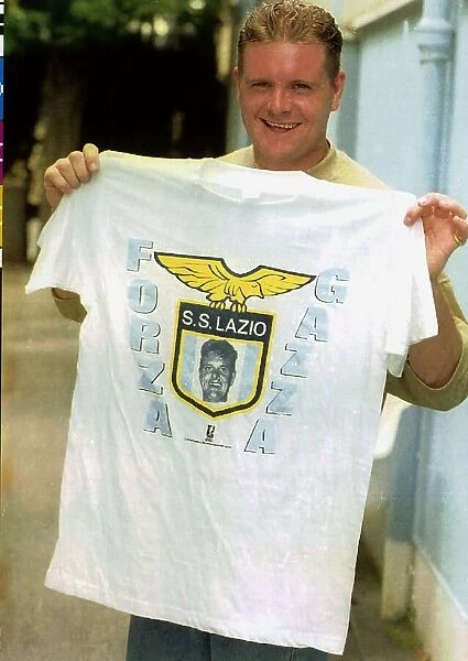Lazio footballer Paul Gascoigne holds a club t shirt after a training session 26th