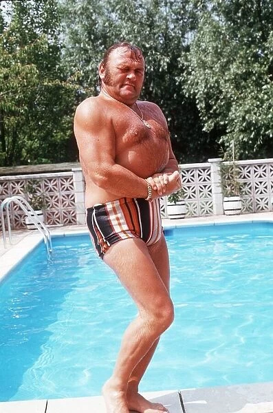 Les Dawson Comedian standing on side of swimming pool at home in St Anne