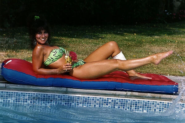 Linda Lusardi Model  /  TV Presenter laying on lilo beside pool August 1990