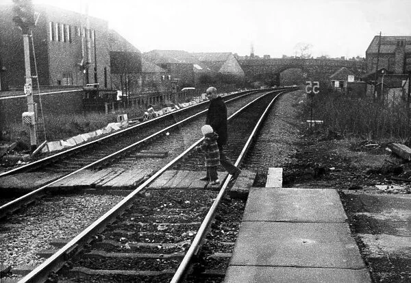 A man with a young child illegally crossing the railway line at West Jesmond Station