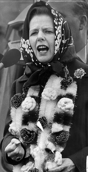 Margaret Thatcher covered in garlands giving speech during visit to the Midlands - June