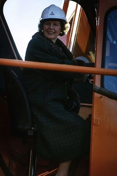 Margaret Thatcher sitting in a crane in driver's cabin while on an industrial visit