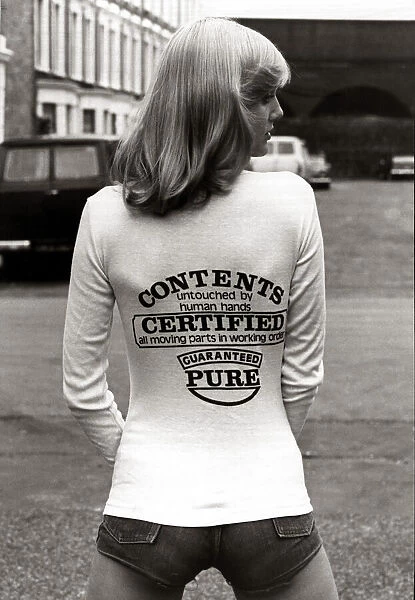 A model wearing a t-shirt with a joke message on the back August 1976