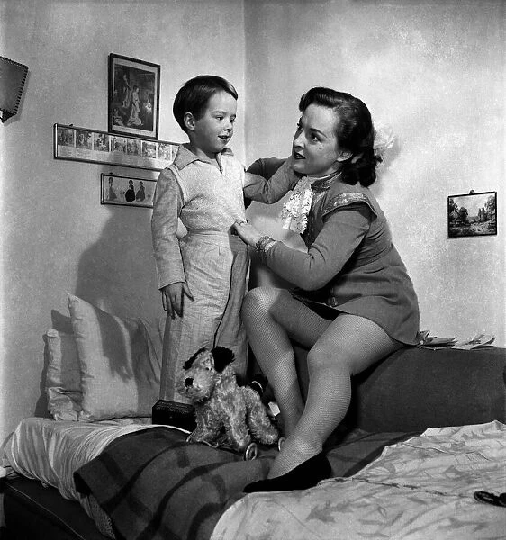 Mother caring for her son, seen here putting him to bed. December 1952 C6310-001