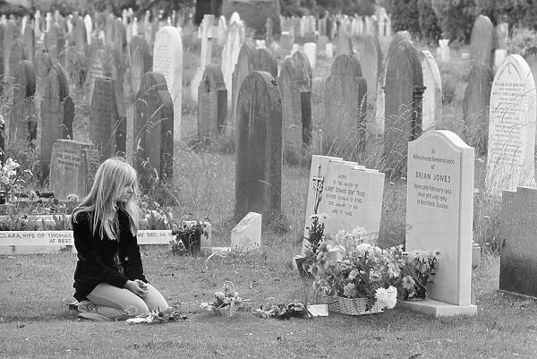 Mourner Margaret Lowe kneels at the grave stone of former Rolling Stones guitarist Brian