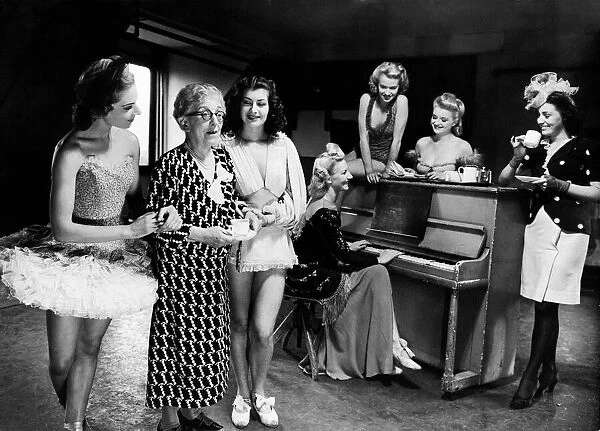 Mrs Laura Henderson owner of the Windmill Theatre seen here taking coffee with some of