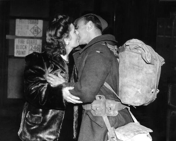 Mrs Wells of Leigh On Sea greets her husband with a kiss at the railway station after