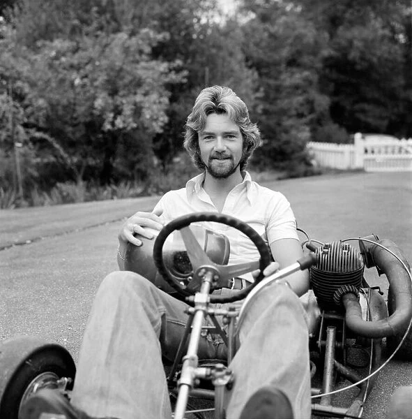 Noel Edmonds at home relaxing in the garden riding a go kart. September 1976