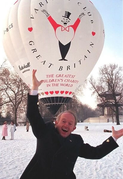 PAUL DANIELS, STANDING IN SNOW IN FRONT OF HOT AIR BALLOON FOR VARIETY CLUB