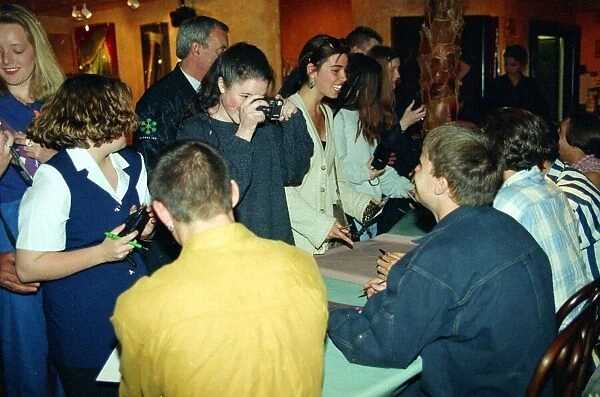 Pop group Take That sign autographs and pose for pictures for girl fans at a signing