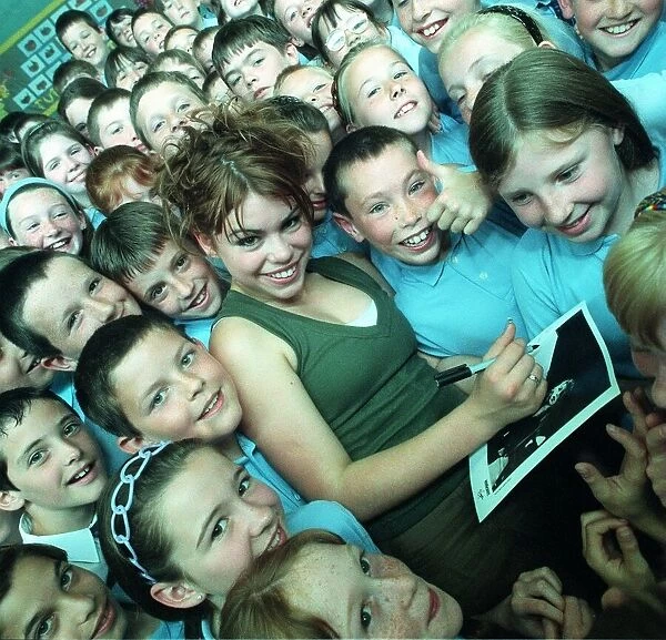 Pop singer Billie Piper signs autographs for a crowd of children June 1998