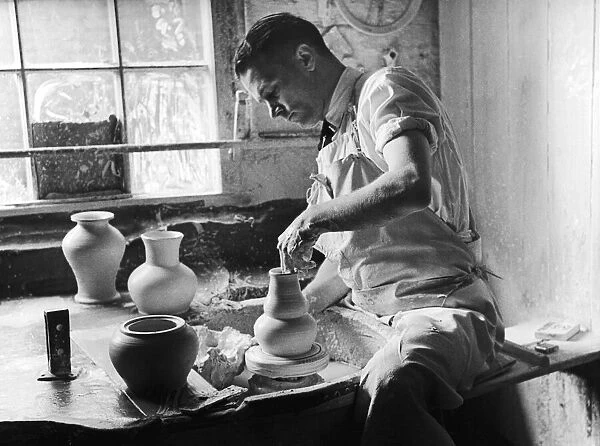 A potter at the Minton China Works in Stoke On Trent, creates a vase on his spinning