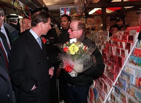 Prince Charles looks at Valentine cards at Dudley market while police officers in