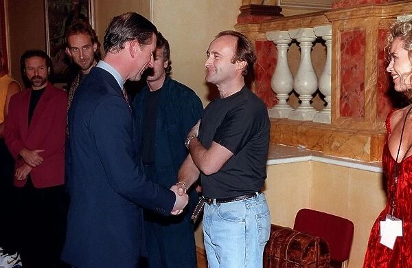 Prince Charles November 1992 shakes hands with musician Phil Collins as the rest of