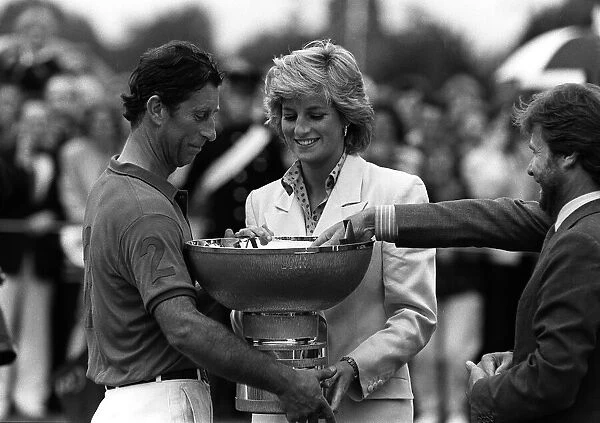 PRINCE CHARLES AND PRINCESS DIANA. CHARLES BEING PRESENTED WITH A TROPHY FOR WINNING SOME