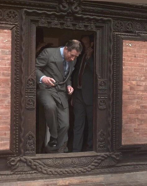 Prince Charles walking through a low temple door Feb 1998 during his visit to
